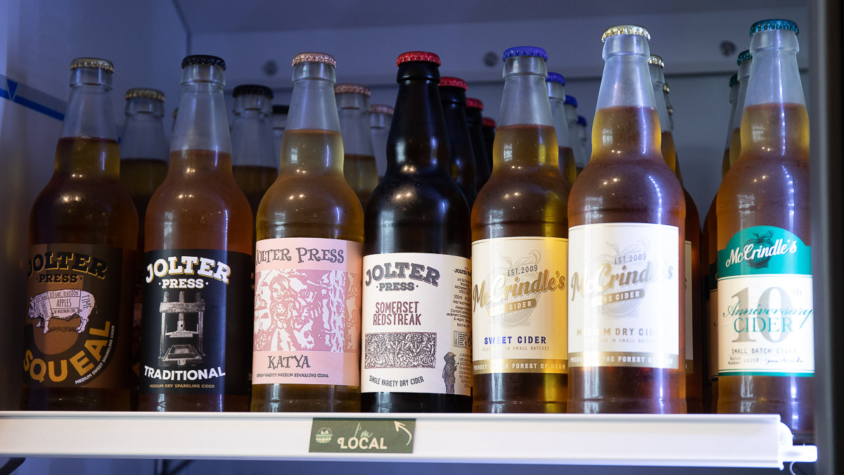 A row of local Forest of Dean ciders in a display fridge